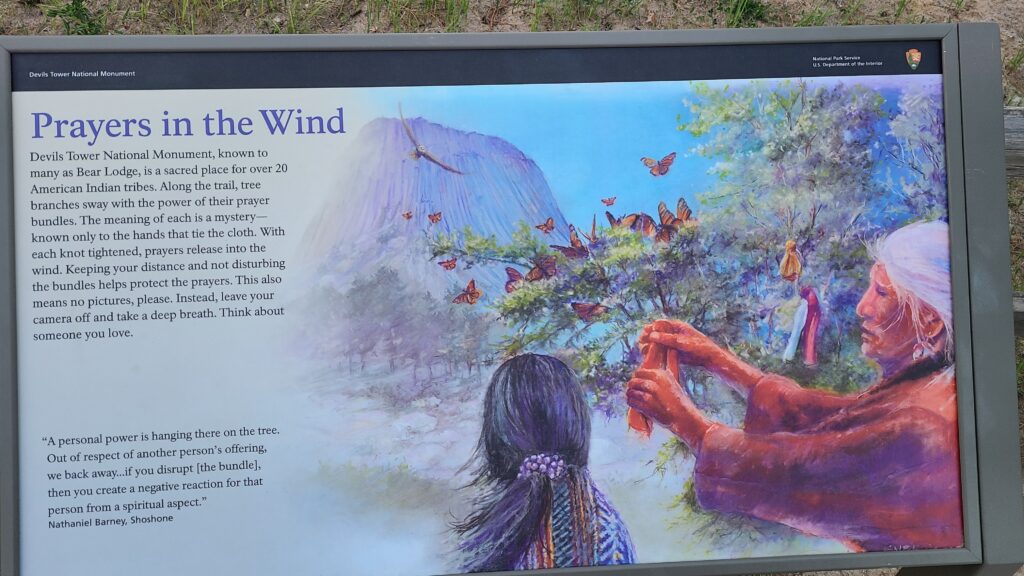 Sign at Devils Tower explaining that Native American tribes still come here to place prayer bundles in the trees.